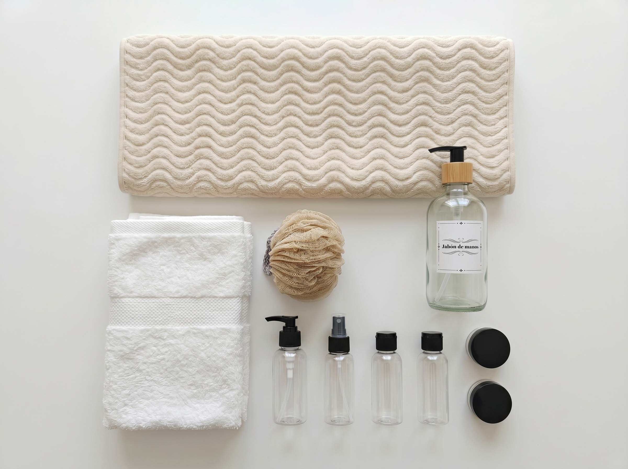 Bathroom Premium towels, dispenser, travel bottles, jars, and laundry bag flat lay